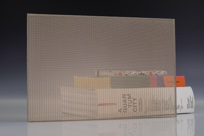 Četverokutni komad stakla s brončanom mrežicom i knjige na neutralnoj pozadini
