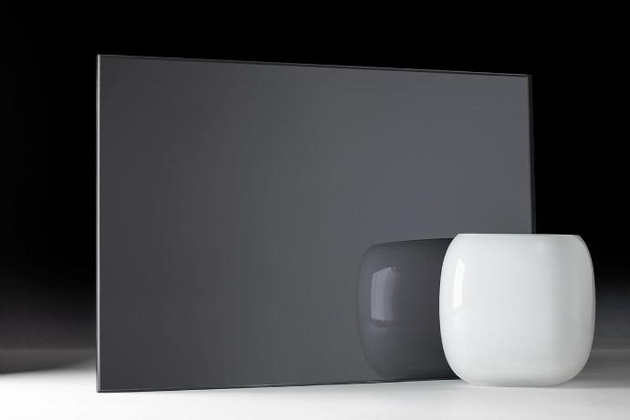 A square piece of grey mirror and a bowl on a dark background