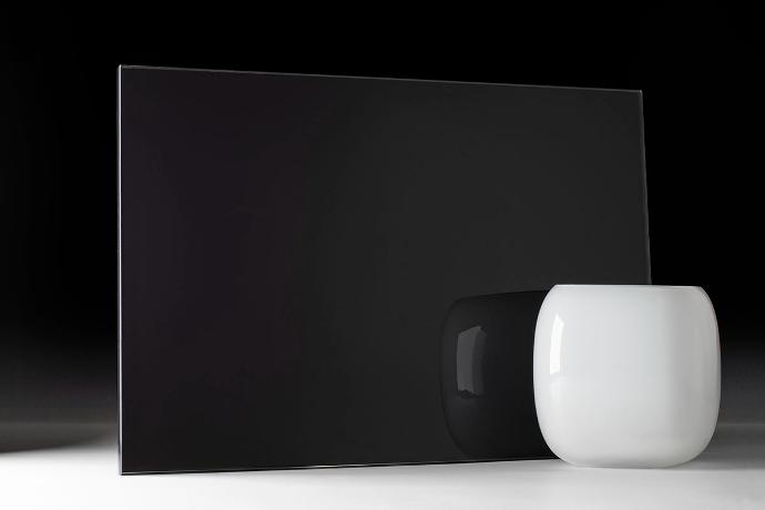 A square piece of mirror in black and a bowl on a dark background