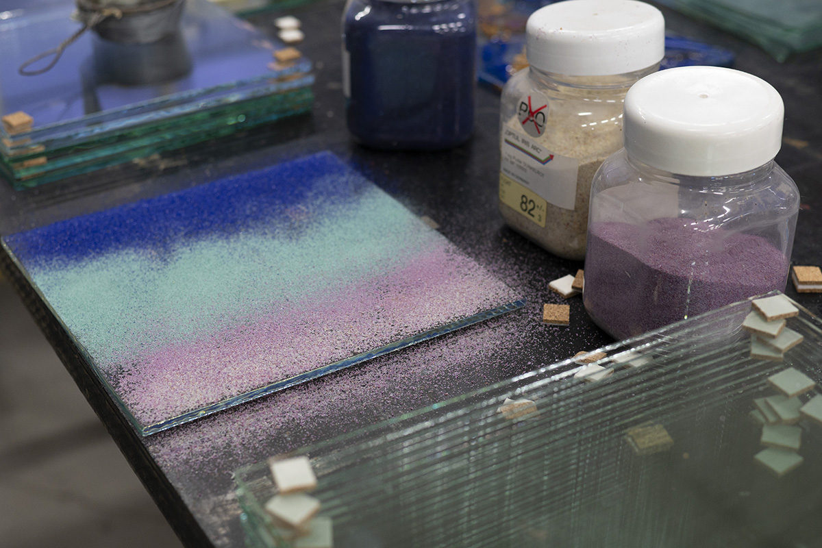 Staklene ploče i pigmenti na radnom stolu.