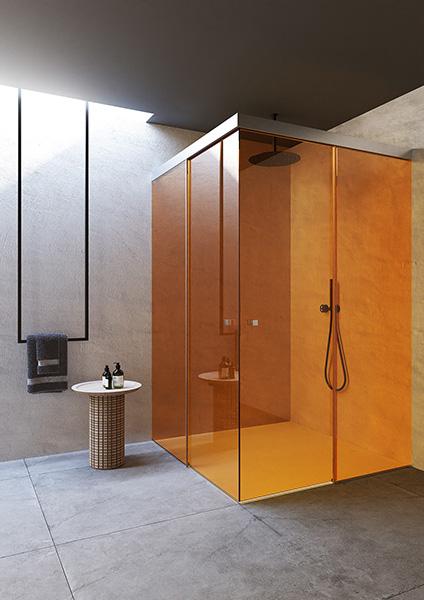 Interior of a modern bathroom with a brightly colored glass shower cabin.