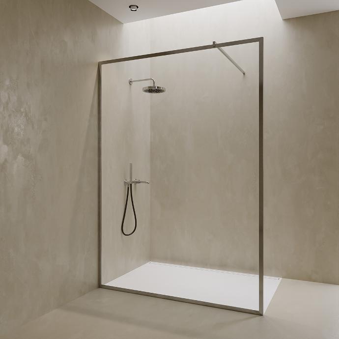 Walk-in shower in a niche with one fixed glass panel.